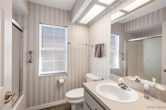 full bathroom with vanity, toilet, and bath / shower combo with glass door