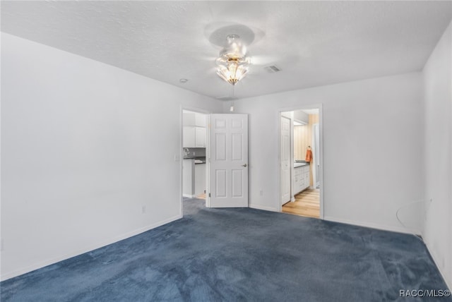 spare room with a textured ceiling, carpet floors, and ceiling fan