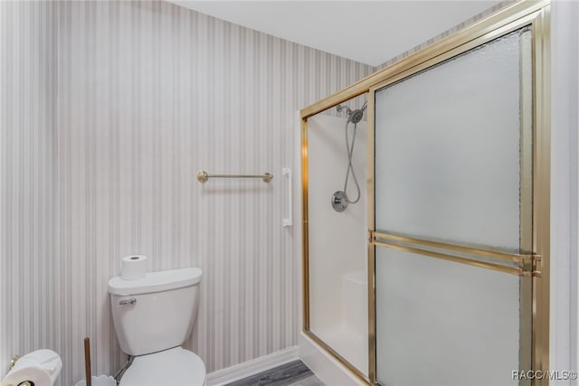 bathroom featuring hardwood / wood-style floors, toilet, and walk in shower