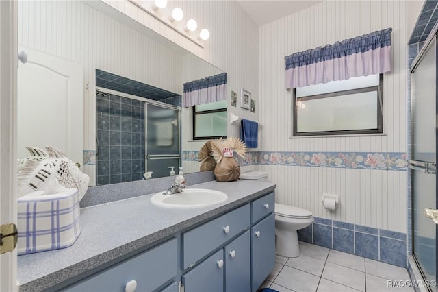 bathroom featuring a shower with shower door, tile patterned floors, vanity, and toilet