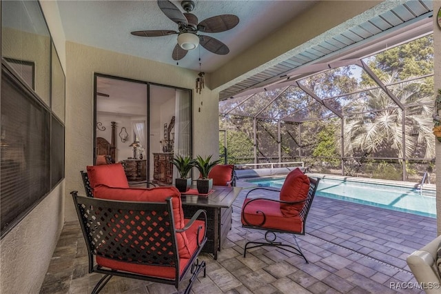 view of patio featuring ceiling fan and glass enclosure