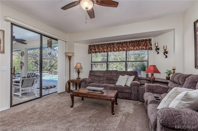 carpeted living room featuring a textured ceiling and ceiling fan