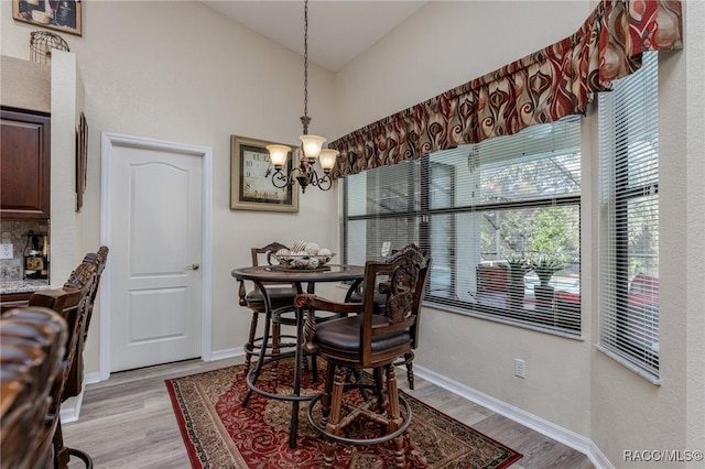 dining space with light wood-type flooring and a chandelier