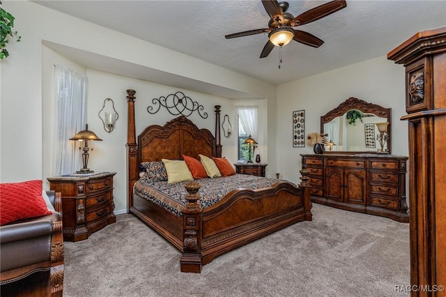 carpeted bedroom featuring a textured ceiling and ceiling fan