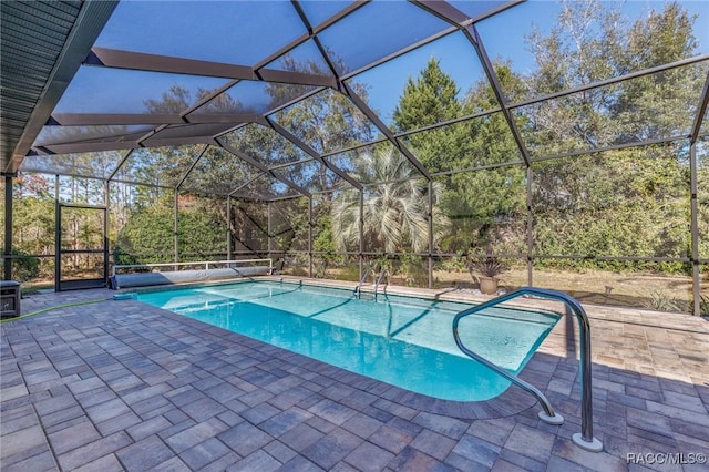 view of swimming pool featuring glass enclosure and a patio area