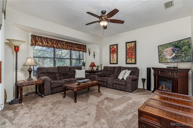 living room featuring light colored carpet, a textured ceiling, and ceiling fan