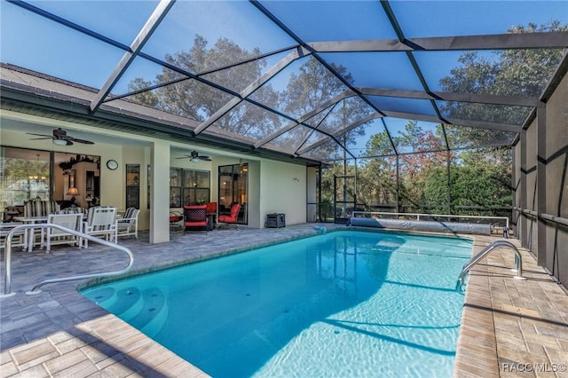 view of pool with a patio, ceiling fan, and glass enclosure