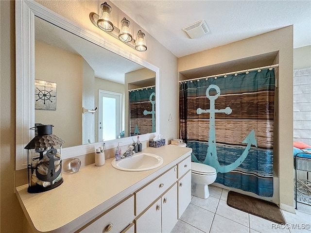 bathroom featuring tile patterned flooring, a textured ceiling, vanity, and toilet