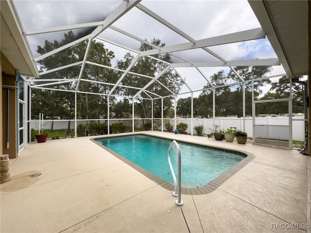 view of pool featuring glass enclosure and a patio