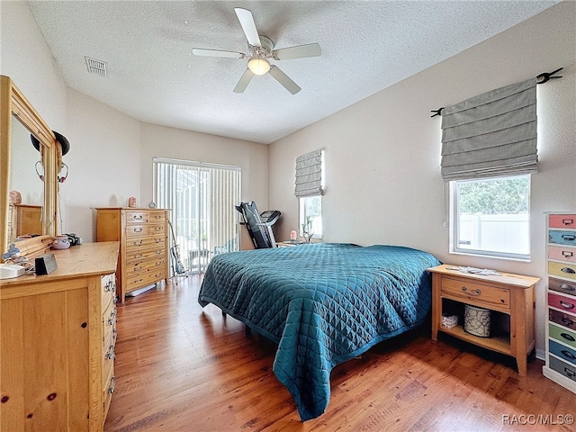 bedroom with ceiling fan, a textured ceiling, and hardwood / wood-style flooring