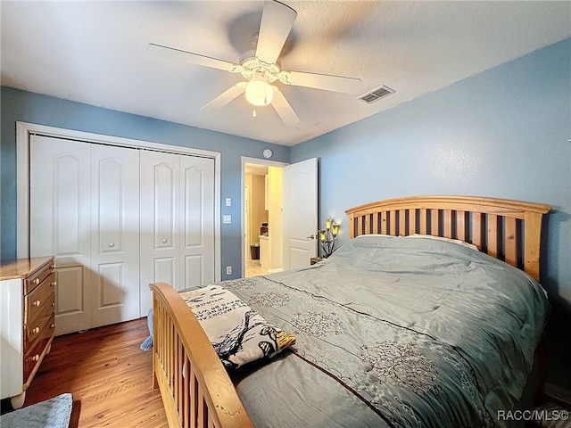 bedroom featuring ceiling fan, light hardwood / wood-style flooring, and a closet