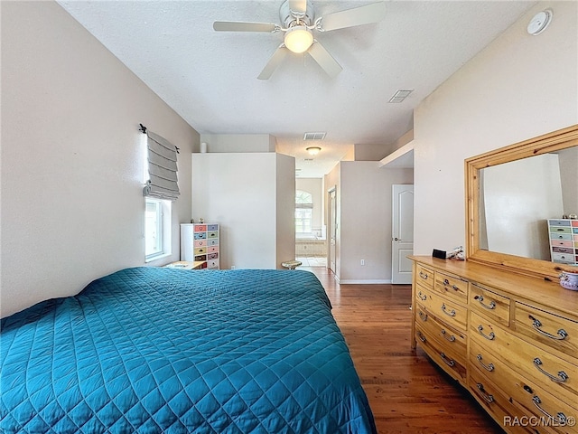 bedroom with connected bathroom, ceiling fan, dark wood-type flooring, and a textured ceiling