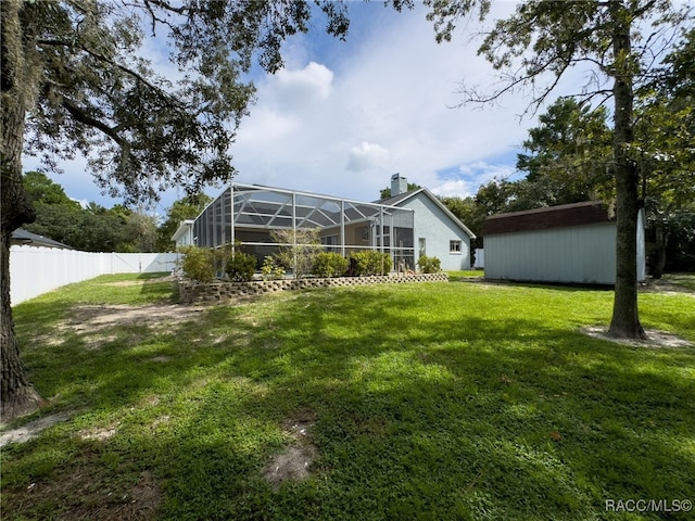 view of yard with a lanai and an outbuilding