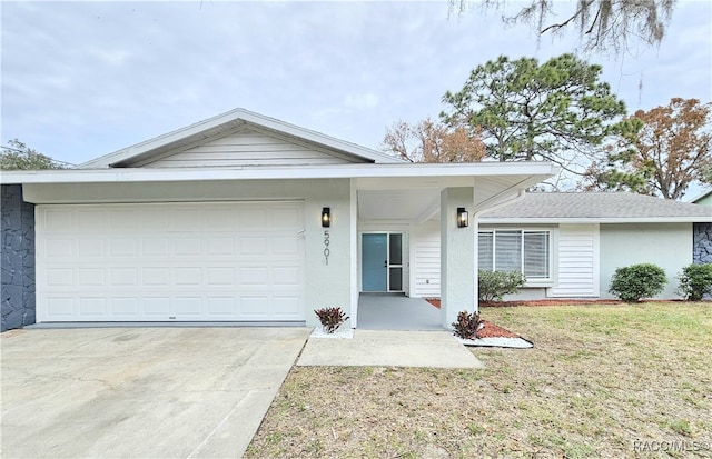 ranch-style house featuring a garage, concrete driveway, a front lawn, and stucco siding