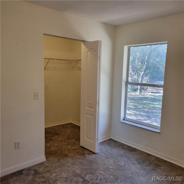 unfurnished bedroom with multiple windows and a closet