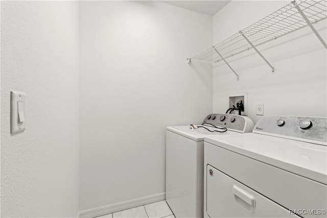 laundry room featuring light tile patterned floors and washing machine and clothes dryer