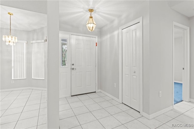 tiled foyer featuring an inviting chandelier