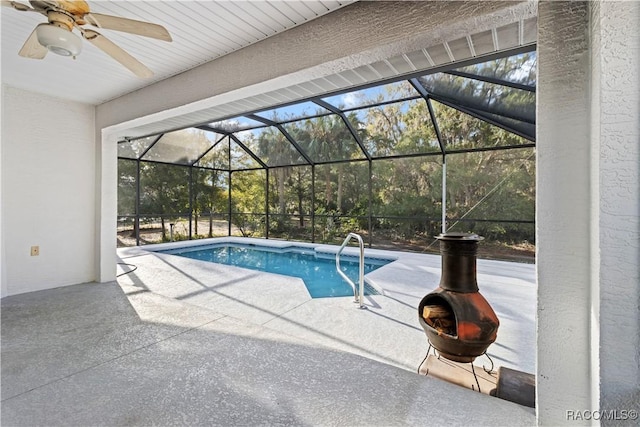 view of pool with a patio, ceiling fan, and glass enclosure