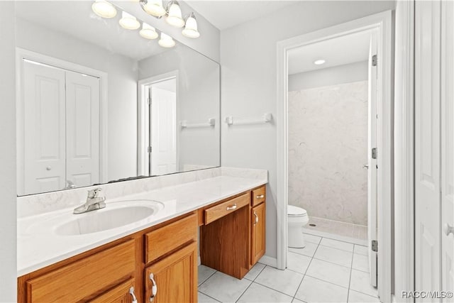 bathroom featuring vanity, a shower, tile patterned floors, and toilet