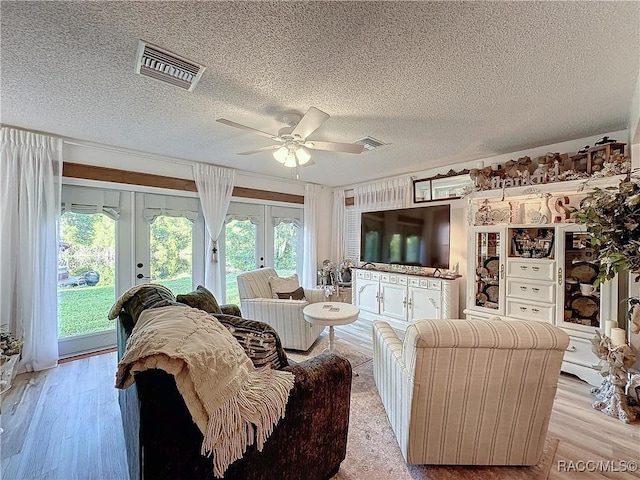 4101 E Gloria Dr, Hernando, FL 34442 - living area featuring french doors, a textured ceiling, plenty of natural light, and light wood-style floors