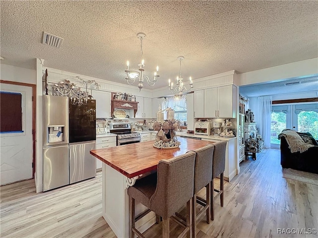4101 E Gloria Dr, Hernando, FL 34442 - kitchen featuring stainless steel appliances, a chandelier, light wood-style floors, butcher block countertops, and a textured ceiling
