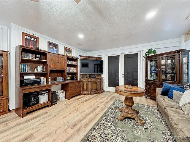 4101 E Gloria Dr, Hernando, FL 34442 - living room featuring light wood-style floors, french doors, and a textured ceiling