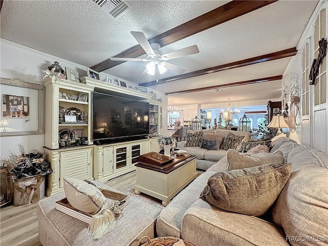 4101 E Gloria Dr, Hernando, FL 34442 - living room with beamed ceiling, a textured ceiling, a chandelier, light wood-type flooring, and a ceiling fan