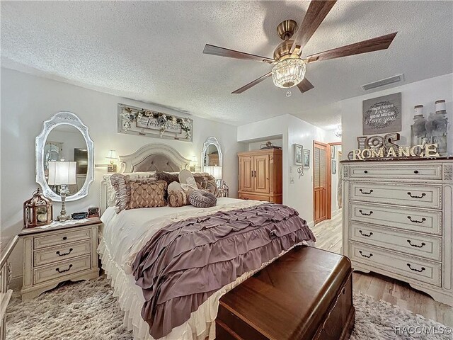 4101 E Gloria Dr, Hernando, FL 34442 - bedroom with a textured ceiling, light wood-style flooring, and ceiling fan