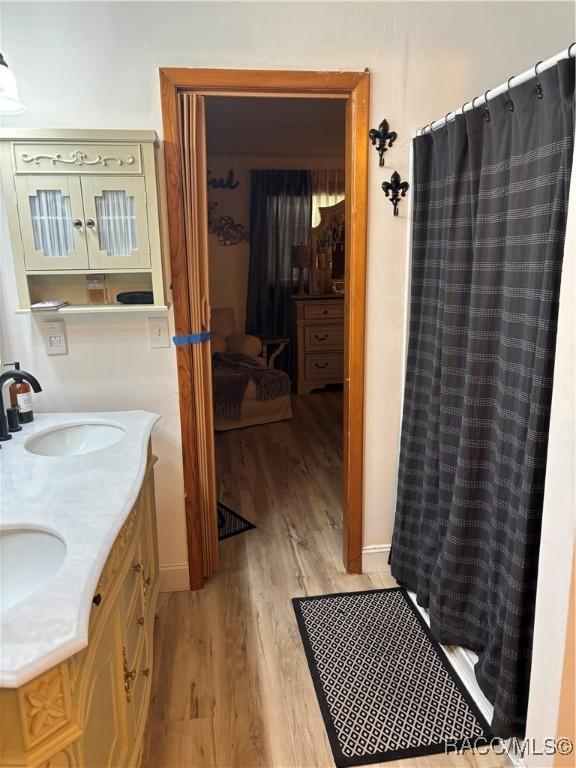 4101 E Gloria Dr, Hernando, FL 34442 - bathroom with wood finished floors, double vanity, and a shower with shower curtain