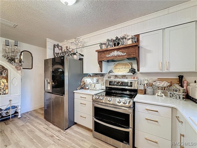 4101 E Gloria Dr, Hernando, FL 34442 - kitchen featuring appliances with stainless steel finishes, light countertops, a textured ceiling, light wood finished floors, and white cabinets