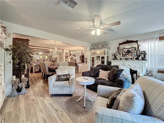 4101 E Gloria Dr, Hernando, FL 34442 - living area with a chandelier, light wood-type flooring, ceiling fan, and a textured ceiling