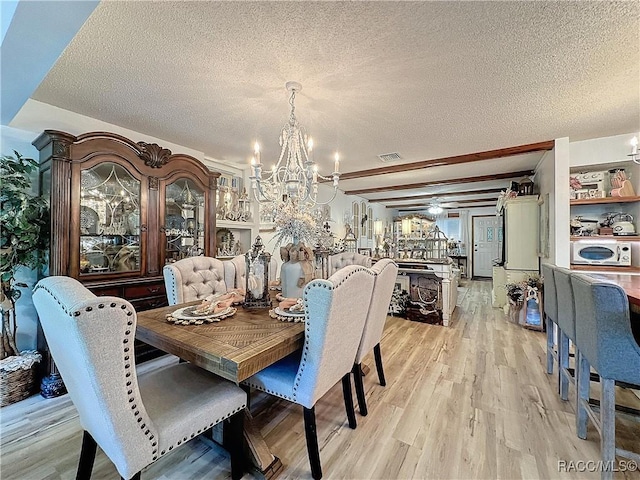 4101 E Gloria Dr, Hernando, FL 34442 - dining area featuring a chandelier, a textured ceiling, and light wood-style flooring