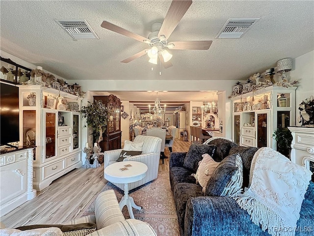 4101 E Gloria Dr, Hernando, FL 34442 - living room with a chandelier, a textured ceiling, light wood-style flooring, and ceiling fan