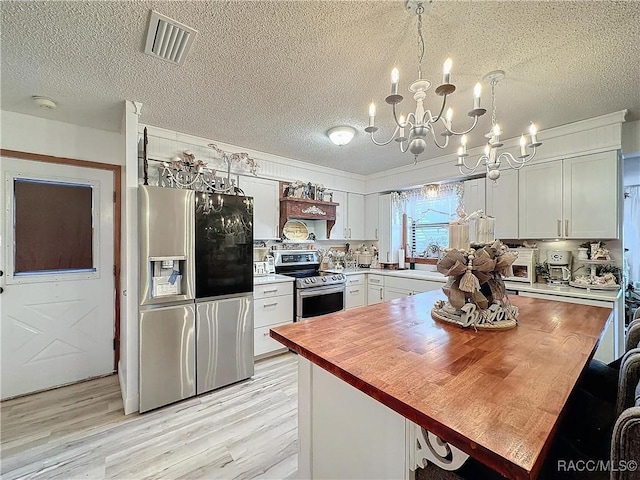 4101 E Gloria Dr, Hernando, FL 34442 - kitchen featuring appliances with stainless steel finishes, wood counters, a chandelier, a textured ceiling, and white cabinets