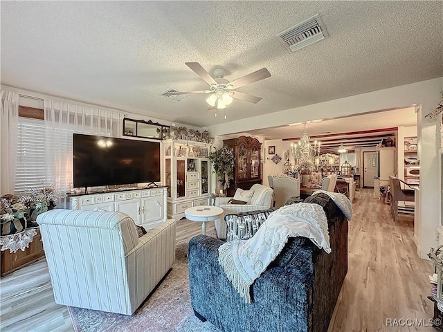 4101 E Gloria Dr, Hernando, FL 34442 - living area featuring a textured ceiling, a ceiling fan, light wood-style flooring, and a chandelier