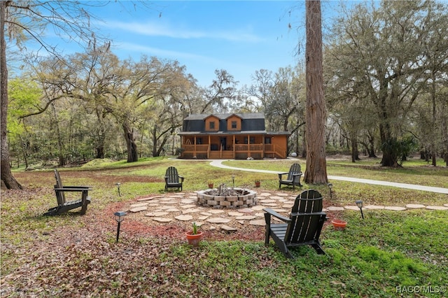 view of home's community with an outdoor fire pit and a yard