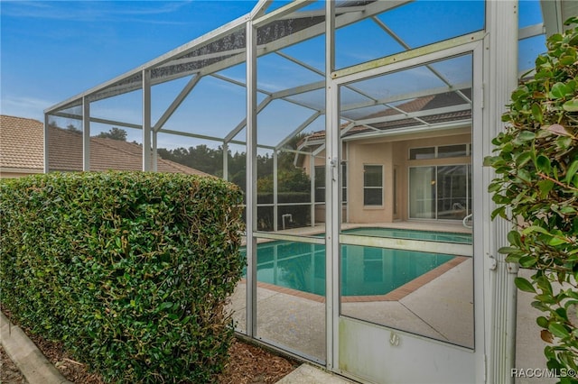 view of swimming pool with a lanai and a patio area