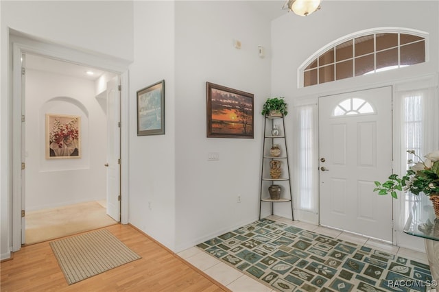 foyer featuring wood-type flooring and a towering ceiling