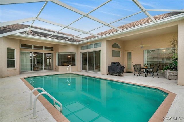 view of pool featuring ceiling fan, a patio, and glass enclosure