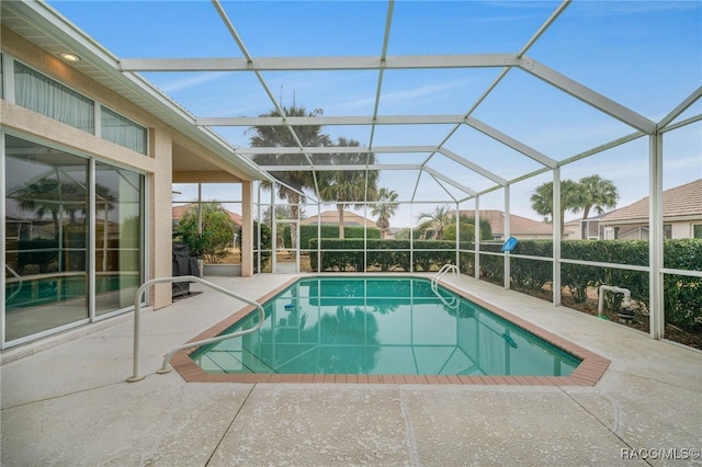 view of swimming pool featuring a lanai and a patio area