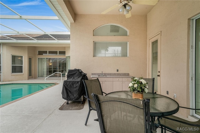 view of patio featuring a lanai and ceiling fan