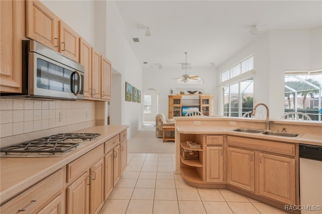 kitchen featuring light brown cabinetry, sink, decorative backsplash, light tile patterned floors, and stainless steel appliances