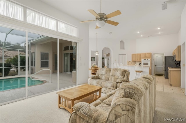 1543 N Killebrew Pt, Hernando, FL 34442 - living area featuring light colored carpet, a high ceiling, ceiling fan, plenty of natural light, and arched walkways