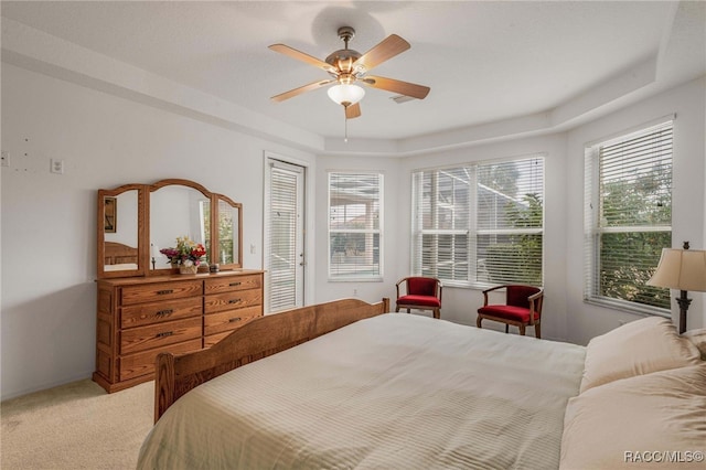 1543 N Killebrew Pt, Hernando, FL 34442 - bedroom with light colored carpet, a tray ceiling, and a ceiling fan