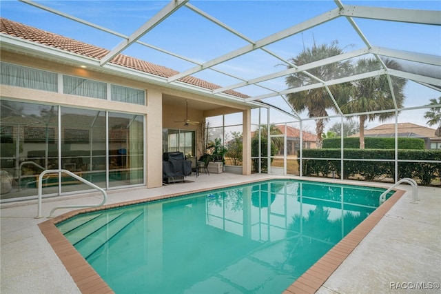 view of swimming pool with a lanai, ceiling fan, and a patio area