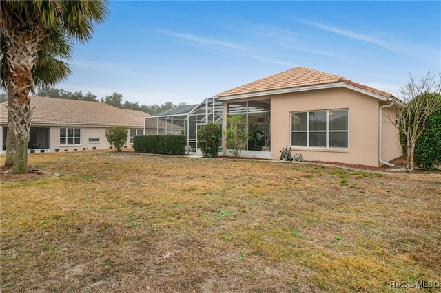 back of house featuring a lanai and a lawn