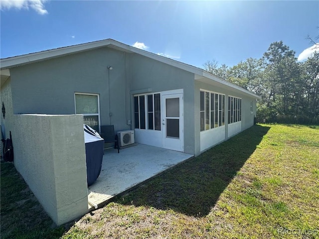 back of property featuring a yard, a patio area, and stucco siding