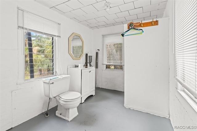 bathroom with concrete flooring and toilet