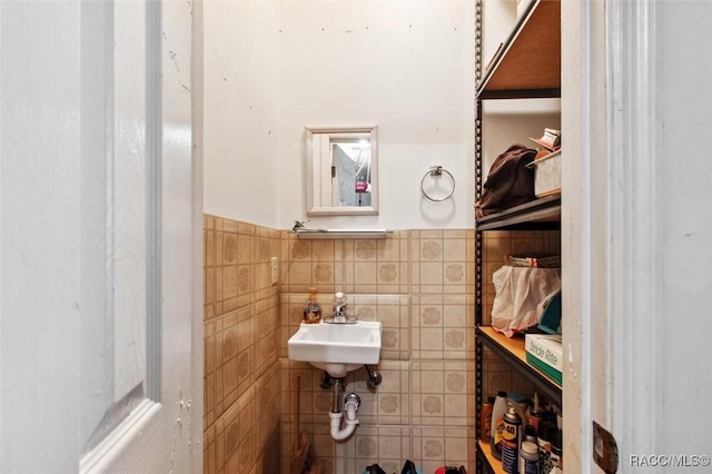 bathroom featuring sink and tile walls