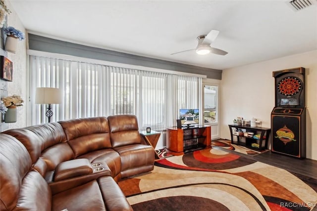 living room featuring ceiling fan, dark hardwood / wood-style floors, and a wealth of natural light